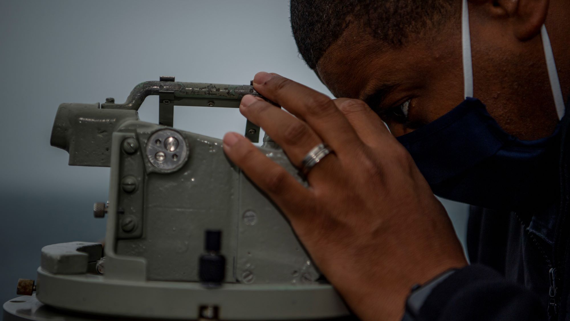 Commanding officer of the guided-missile destroyer USS John Finn looks through an alidade, Taiwan Strait, March 10, 2021. US Navy photo: Jason Waite