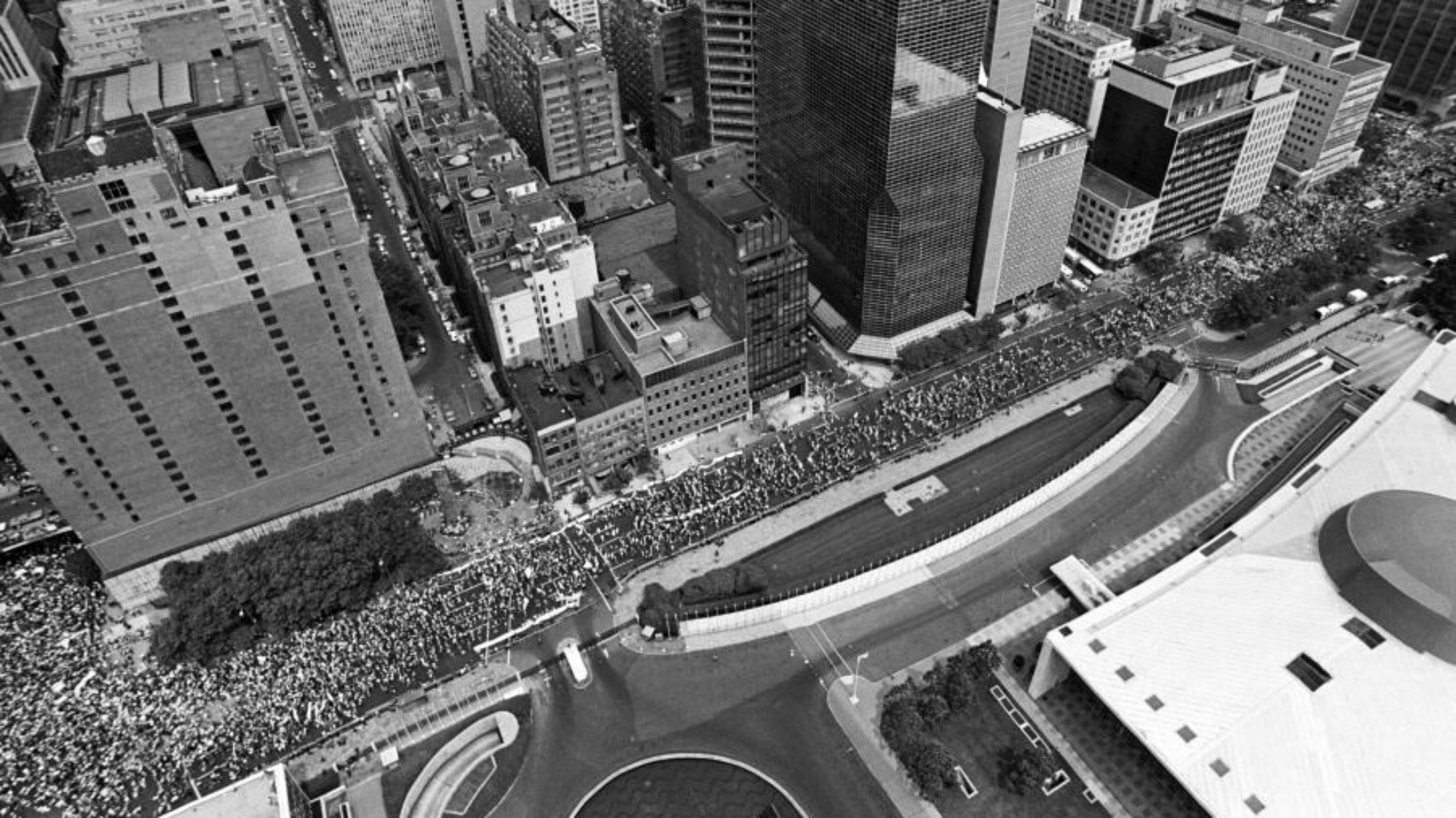 An aerial view of thousands of demonstrators filing past United Nations Headquarters on their way to today's Peace Rally in Central Park. The rally was timed to coincide with the UN General Assembly's second Special Session on Disarmament. An estimated three-quarters of a million people gathered in the cause of world nuclear disarmament, making it the largest demonstration of its kind ever to take place in the United States.